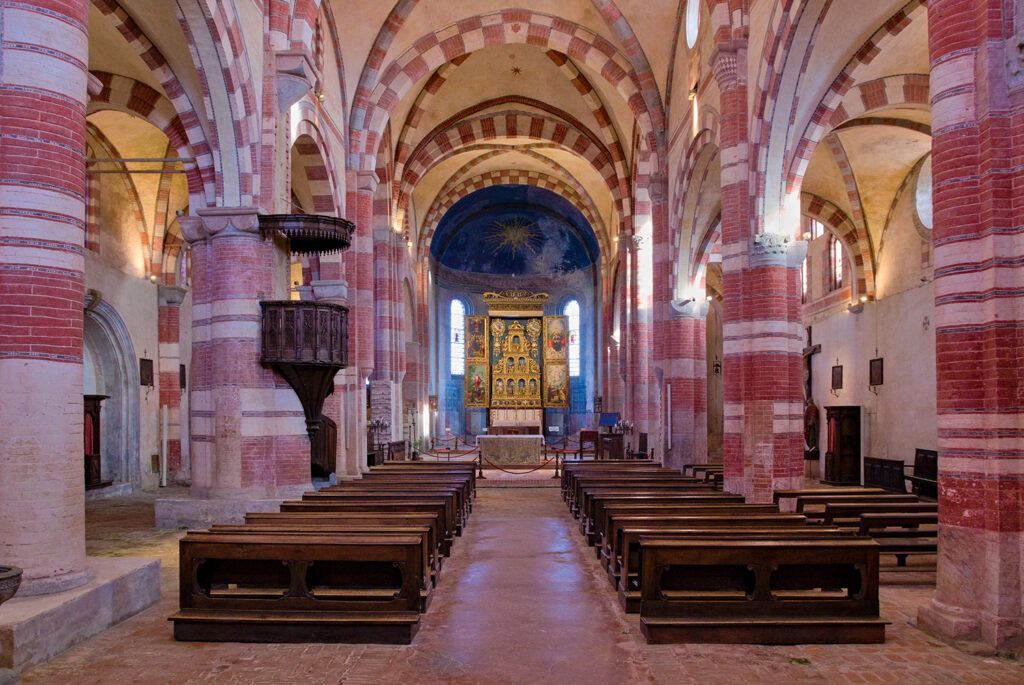 interni della chiesa di Staffarda, con vista centrale su presbiterio e polittico.