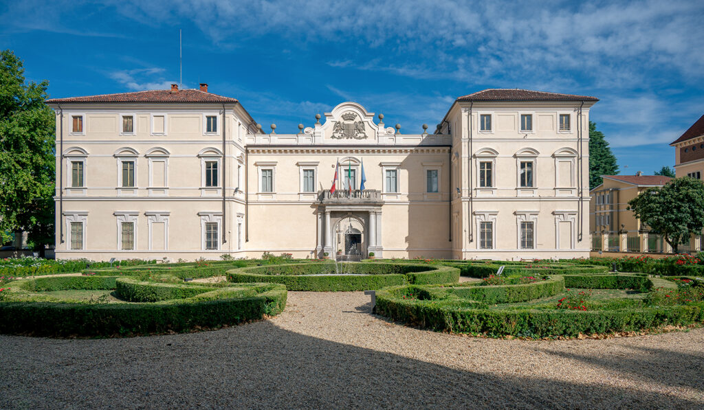 Primo piano del palazzo D'Oria, con siepe del giardino e cielo azzurro sullo sfondo.