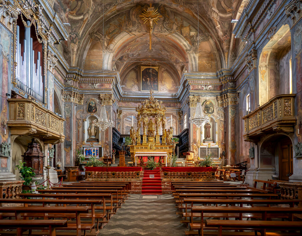 Visuale della chiesa di san Bartolomeo, a Bargomanero, dalll'entrata con navata, presbiterio, altare maggiore e affreschi laterali.