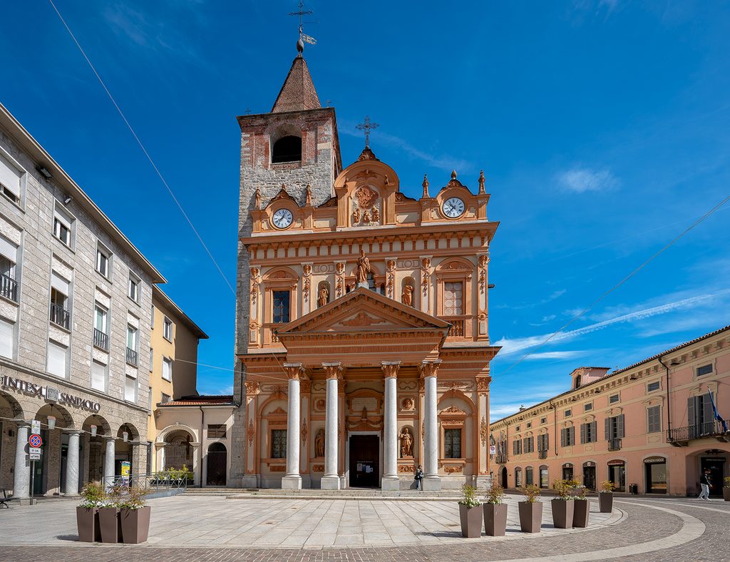 Facciata della chiesa e campanile con cielo azzurro, nella piazza centrale di Borgomanero.