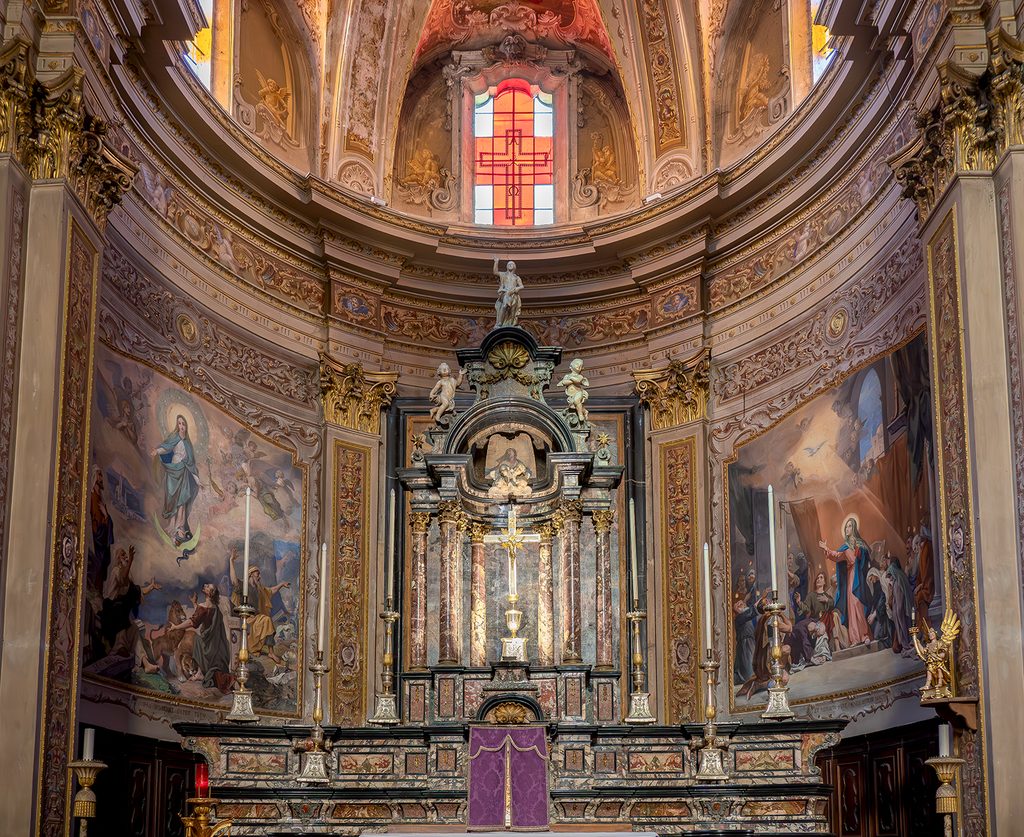Cappella laterale con primo piano dell'altare e affreschi e dipinti alle pareti.